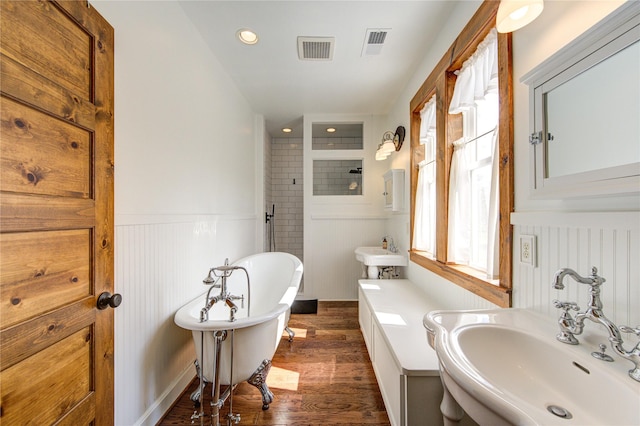 bathroom featuring hardwood / wood-style flooring, double sink, and a tub