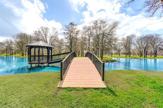 view of dock with a gazebo, a water view, and a yard