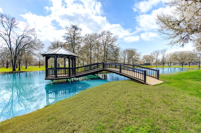 dock area featuring a gazebo, a water view, and a yard