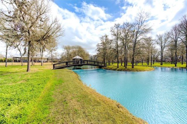 view of swimming pool featuring a water view, a yard, and a gazebo