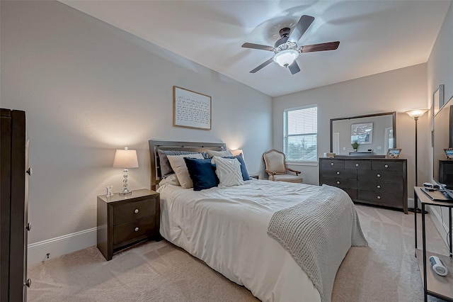 bedroom with ceiling fan, baseboards, and light colored carpet