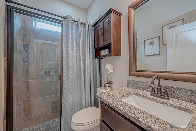 bathroom with toilet, a shower stall, and vanity