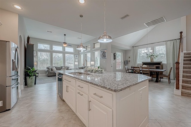 kitchen featuring a center island with sink, stainless steel appliances, visible vents, open floor plan, and white cabinetry