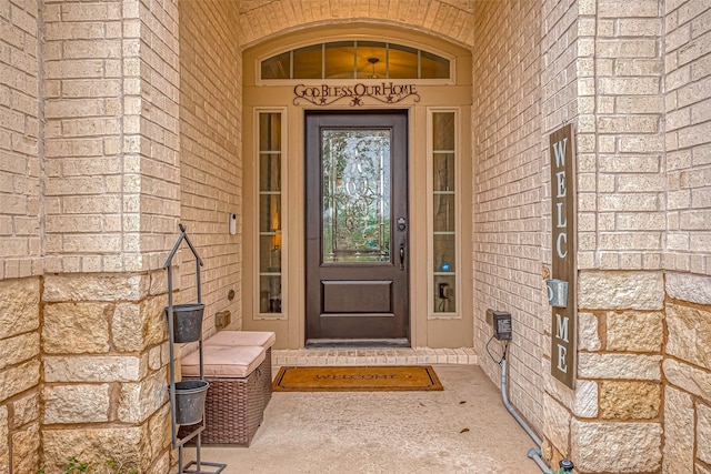 view of exterior entry with brick siding