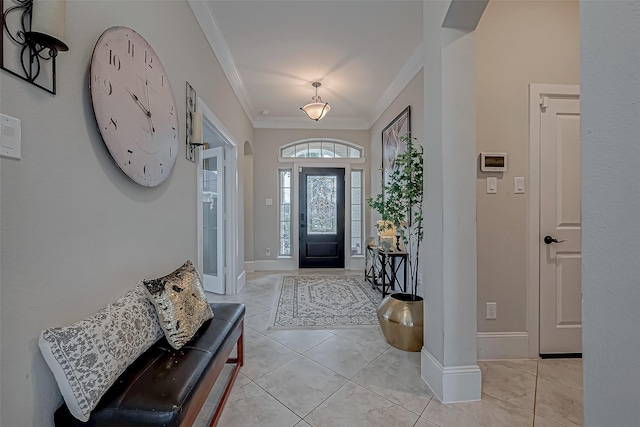 entrance foyer featuring light tile patterned floors, baseboards, and crown molding