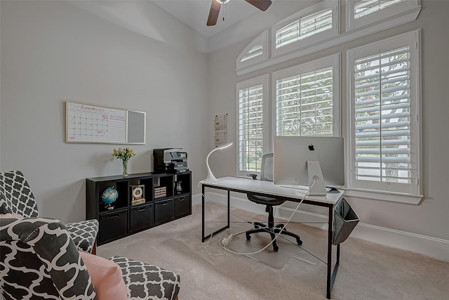 carpeted home office with lofted ceiling, baseboards, and a ceiling fan