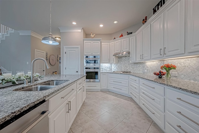 kitchen with under cabinet range hood, stainless steel appliances, a sink, white cabinets, and light stone countertops