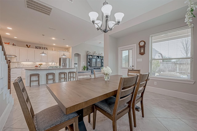 dining space featuring light tile patterned floors, arched walkways, recessed lighting, visible vents, and baseboards