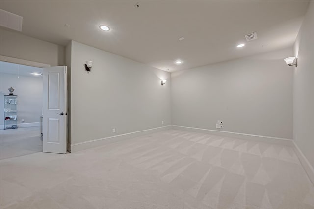 below grade area featuring light carpet, baseboards, visible vents, and recessed lighting