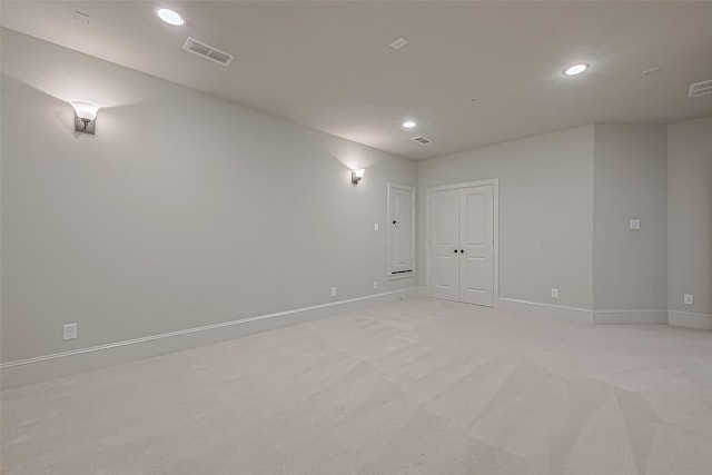 spare room featuring light colored carpet, visible vents, baseboards, and recessed lighting