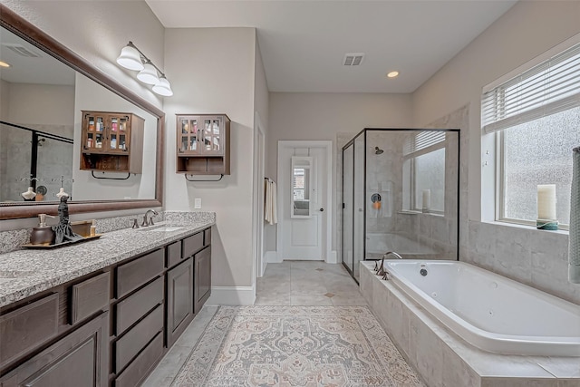 full bathroom featuring a healthy amount of sunlight, visible vents, a bath, and vanity