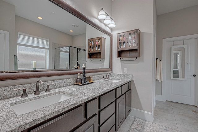 full bath featuring tile patterned flooring, visible vents, a sink, and a shower stall