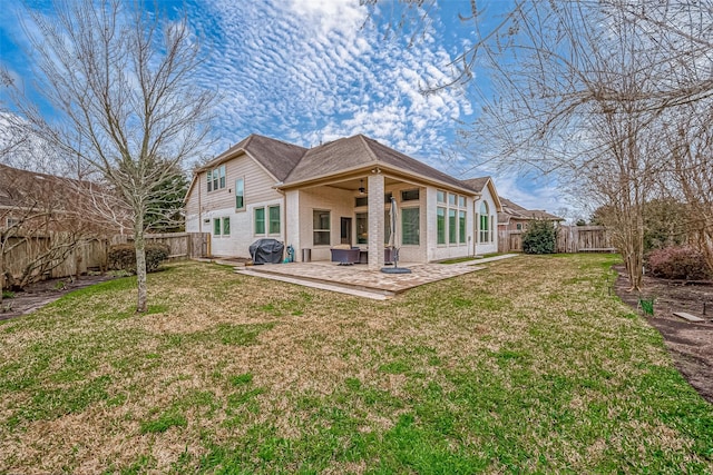 rear view of property featuring a ceiling fan, a lawn, a fenced backyard, a patio area, and brick siding