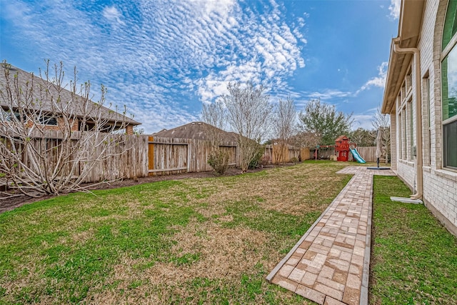 view of yard with a playground and a fenced backyard