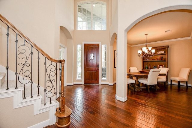 foyer with stairs, dark wood-type flooring, crown molding, and baseboards