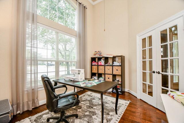 office featuring french doors, a towering ceiling, and dark wood-type flooring