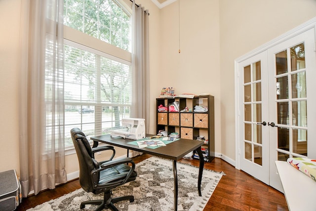 office space featuring french doors, baseboards, wood finished floors, and a towering ceiling