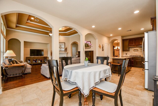 dining space with ornamental molding and a tray ceiling