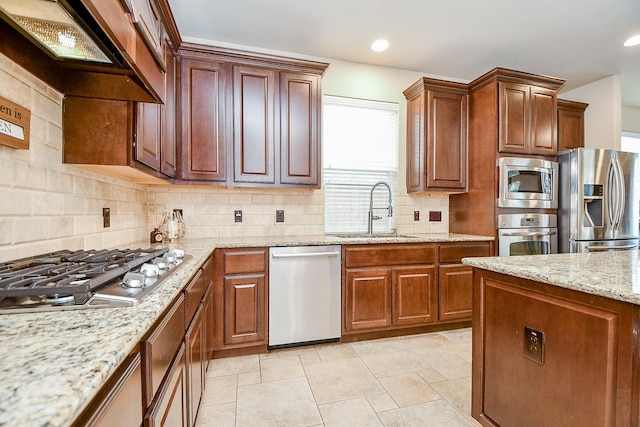 kitchen with a sink, tasteful backsplash, ventilation hood, stainless steel appliances, and light stone countertops