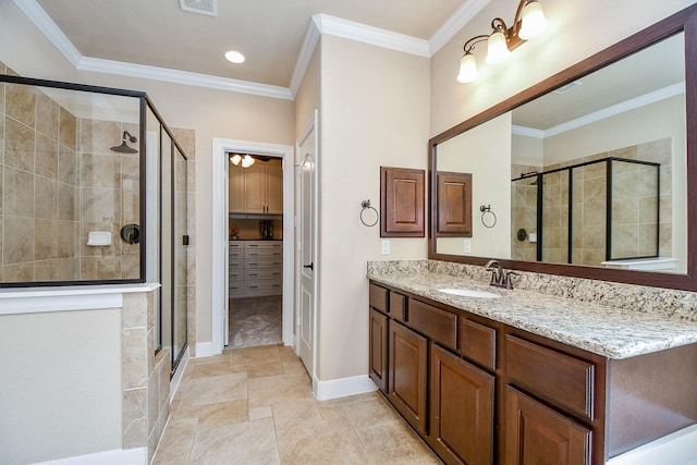 full bathroom featuring vanity, visible vents, baseboards, a shower stall, and crown molding