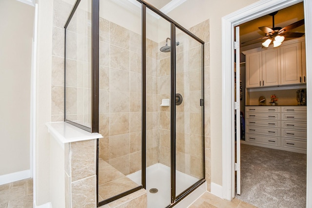 full bath with crown molding, a ceiling fan, and a stall shower