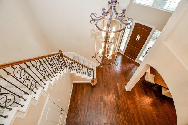 entryway featuring an inviting chandelier, hardwood / wood-style floors, and a high ceiling