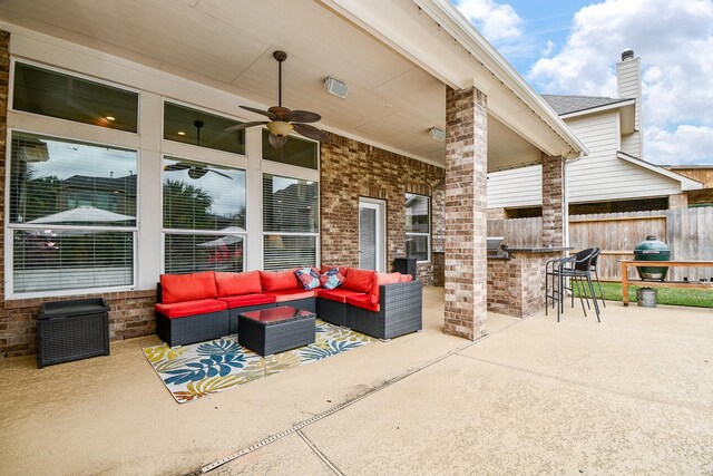 view of patio / terrace featuring an outdoor living space, exterior bar, and ceiling fan