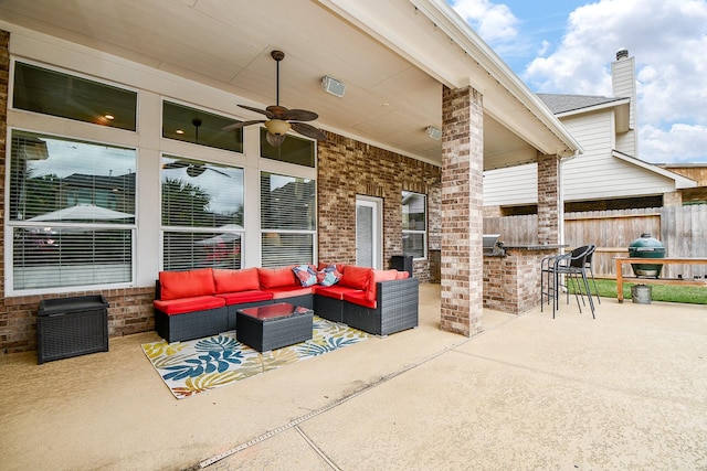 view of patio with fence, ceiling fan, grilling area, outdoor lounge area, and outdoor dry bar