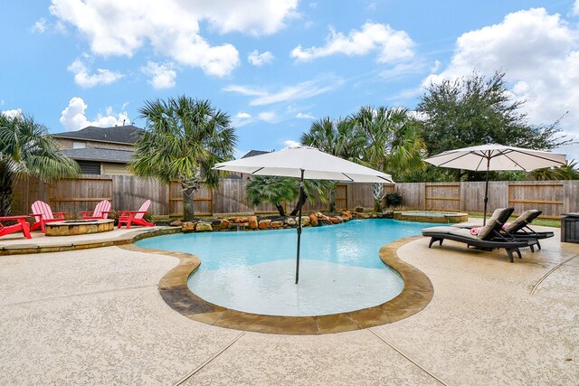 view of pool with an in ground hot tub, a patio, and an outdoor fire pit