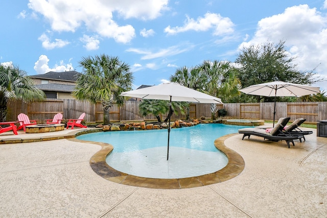 view of pool with an in ground hot tub, a patio area, and a fire pit