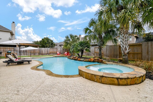 view of pool featuring a patio area and an in ground hot tub