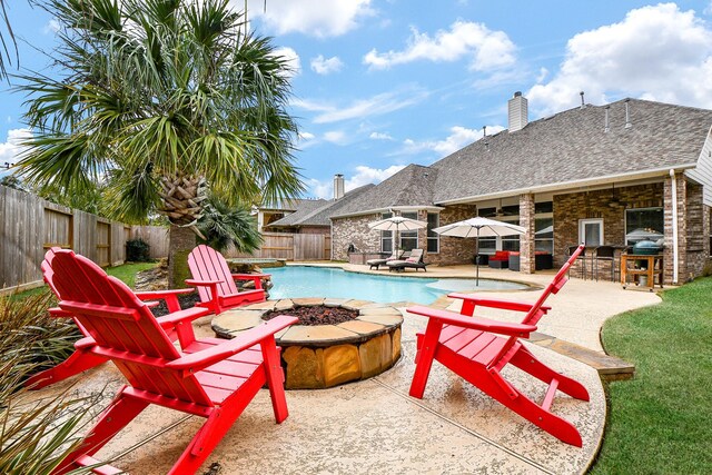 view of swimming pool with area for grilling, a patio area, and a fire pit