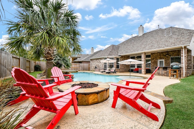 view of swimming pool featuring a patio area, a fire pit, a fenced in pool, and a fenced backyard