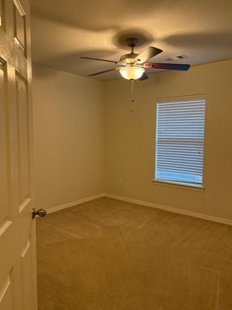 spare room featuring ceiling fan and carpet floors