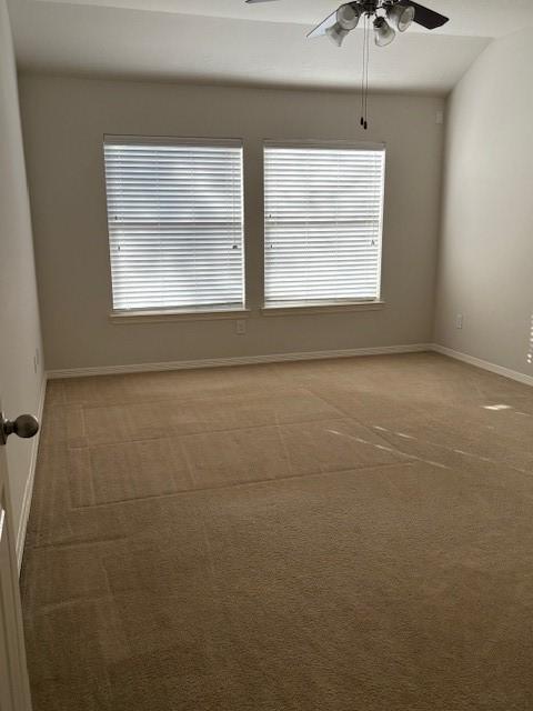 carpeted empty room with plenty of natural light and ceiling fan