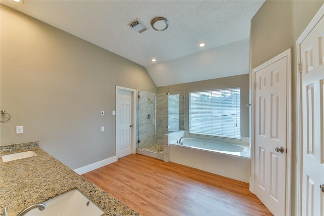 bathroom with lofted ceiling, vanity, plus walk in shower, and wood-type flooring