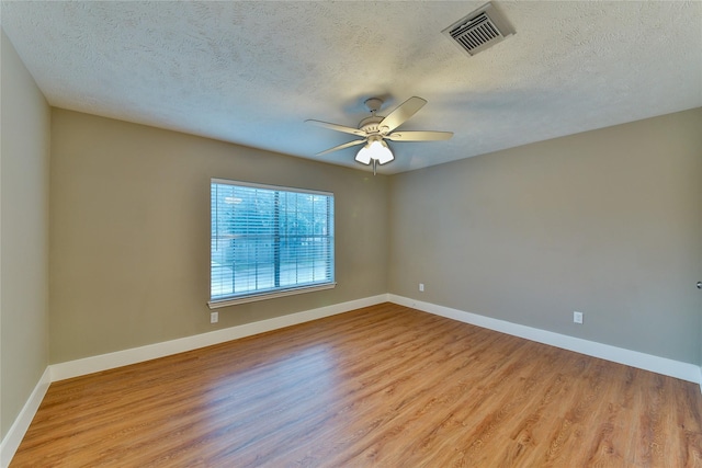 spare room with ceiling fan, light hardwood / wood-style flooring, and a textured ceiling