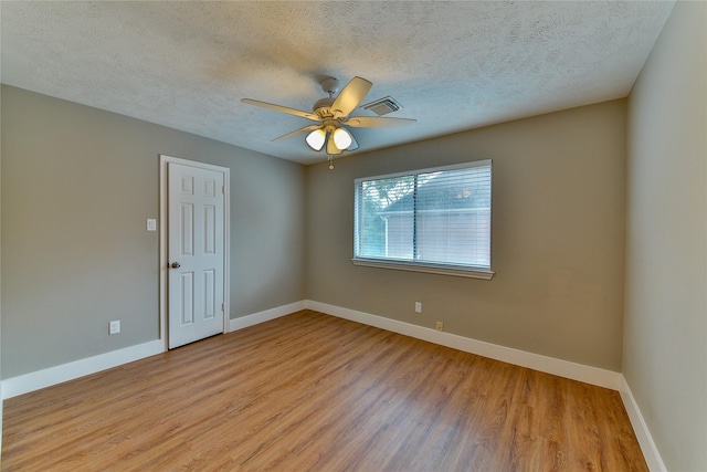 empty room with a textured ceiling, ceiling fan, and light wood-type flooring