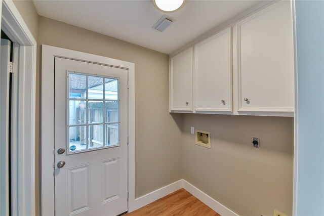 clothes washing area featuring electric dryer hookup, hookup for a washing machine, cabinets, and light wood-type flooring