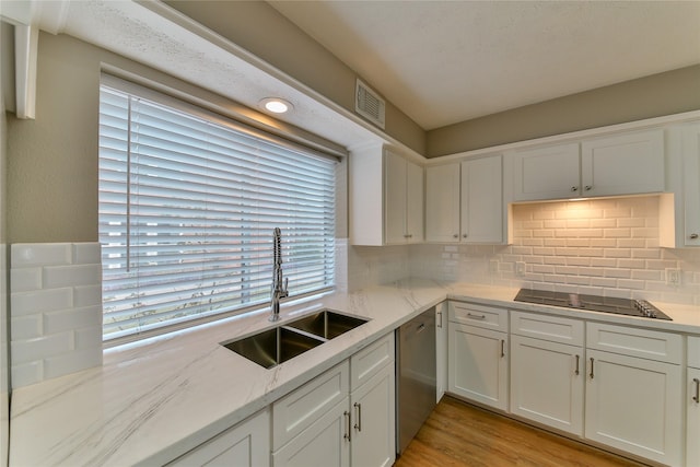 kitchen featuring sink, white cabinetry, black electric cooktop, dishwasher, and light stone countertops