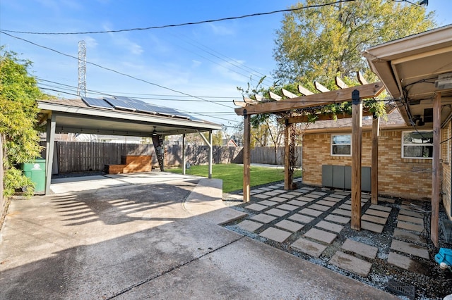 view of patio featuring concrete driveway, a fenced backyard, and a pergola