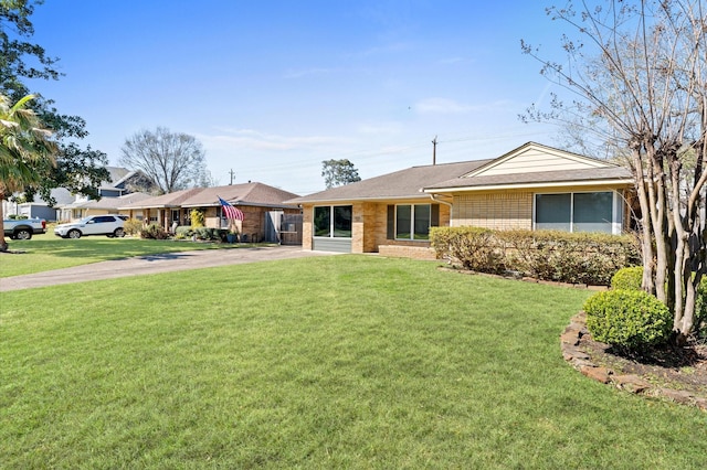 ranch-style house with a front lawn, brick siding, and driveway