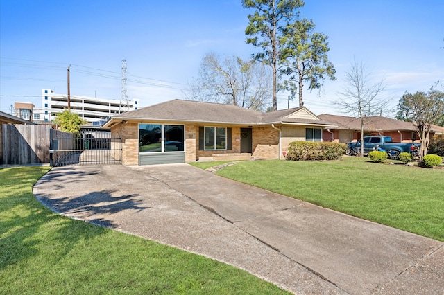 single story home featuring fence, concrete driveway, a front yard, a carport, and brick siding