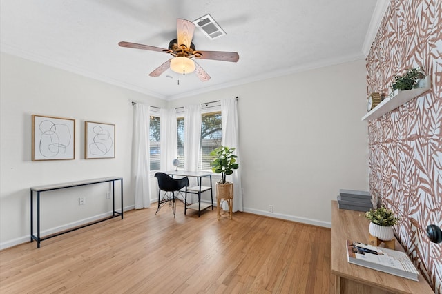 office featuring a ceiling fan, baseboards, visible vents, light wood-style flooring, and crown molding