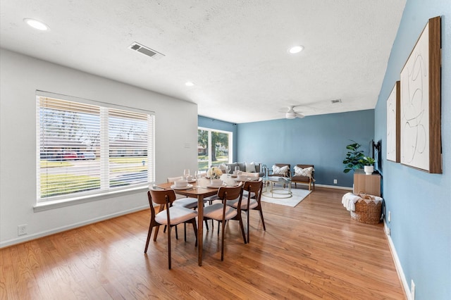 dining space with visible vents, light wood-style flooring, a textured ceiling, recessed lighting, and baseboards