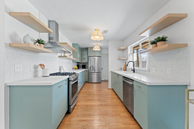 kitchen with visible vents, open shelves, a sink, stainless steel appliances, and wall chimney exhaust hood