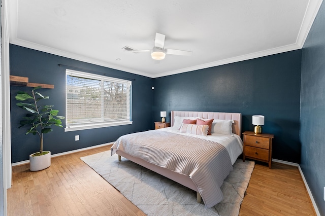 bedroom featuring ceiling fan, crown molding, baseboards, and wood finished floors