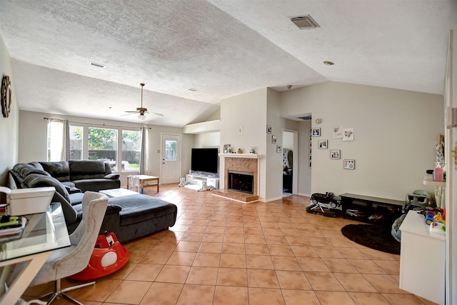 living room featuring light tile patterned flooring, lofted ceiling, a premium fireplace, and a textured ceiling