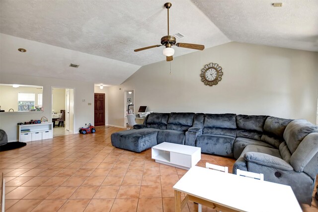 living room with ceiling fan, lofted ceiling, light tile patterned floors, and a textured ceiling