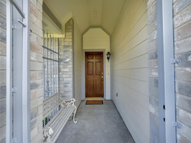 entrance to property featuring stone siding and brick siding